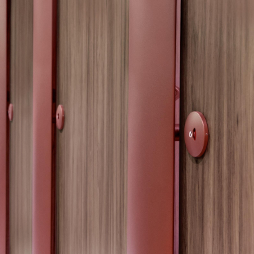 Modern interior featuring red doors against warm wood, showcasing 2023 color trends inspired by bold design choices.