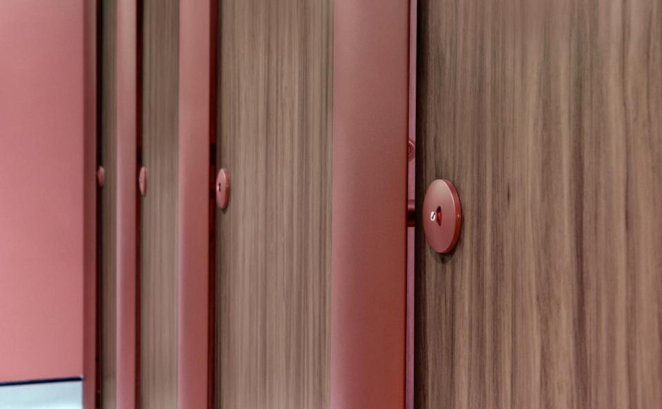 Modern interior featuring red doors against warm wood, showcasing 2023 color trends inspired by bold design choices.