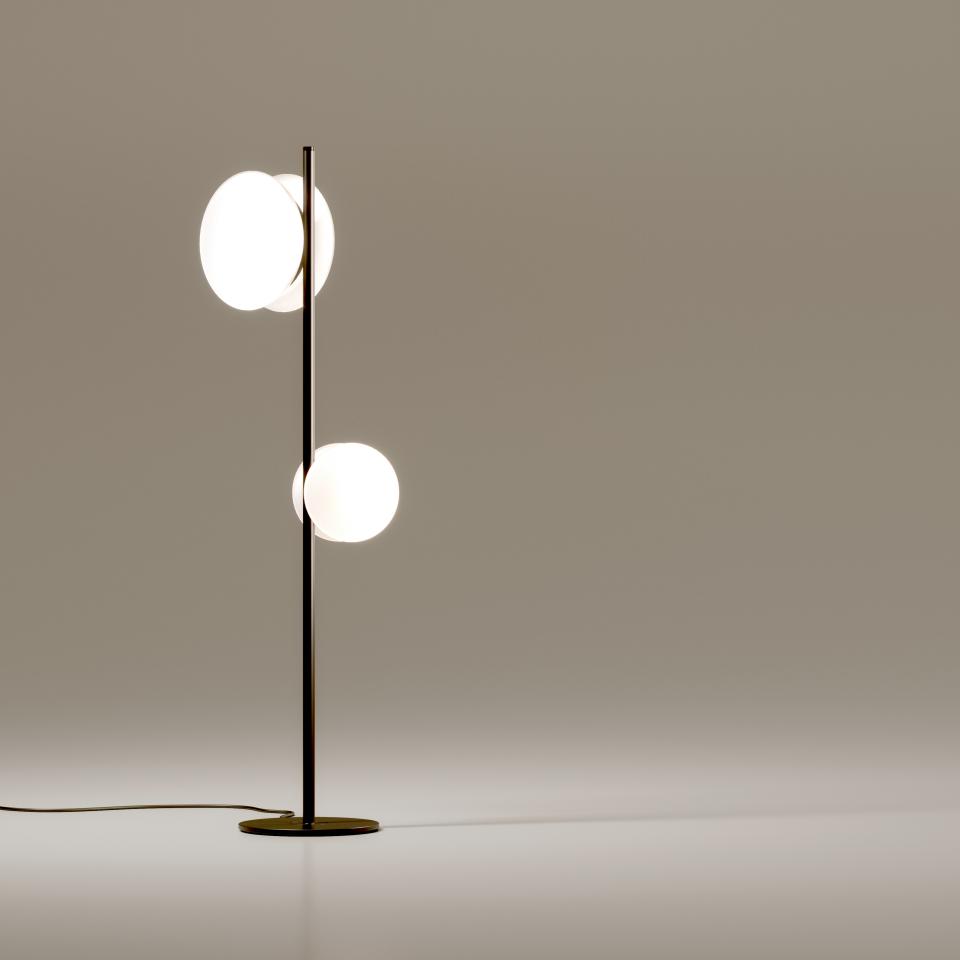 Modern floor lamp design featuring circular glass shades, showcasing Fabbian's blend of beauty and innovation in lighting.