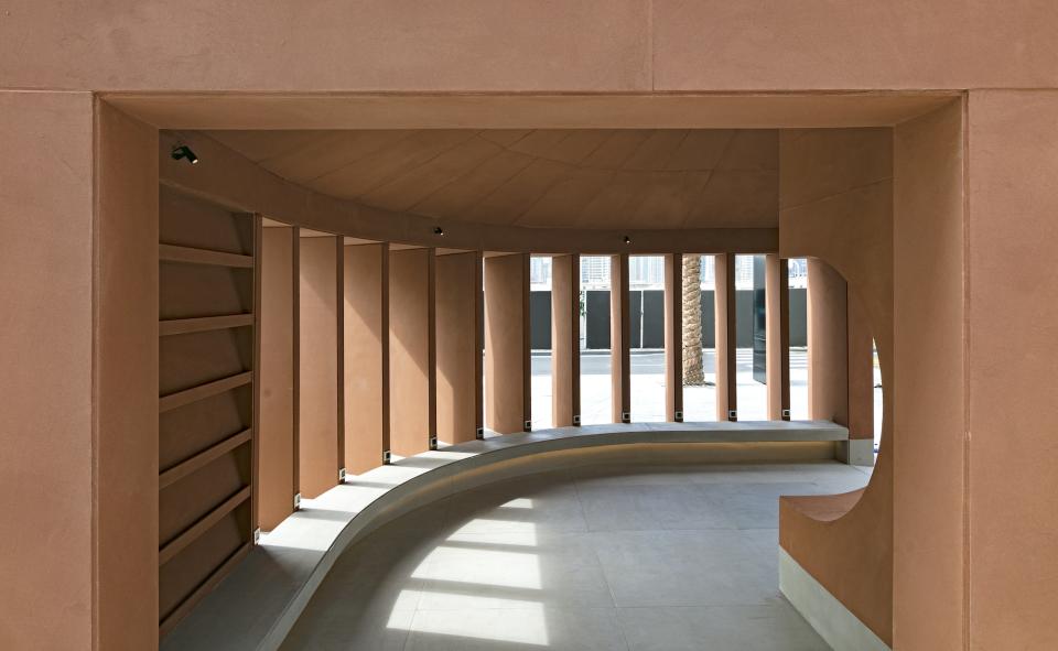 Curved interior space featuring natural light, earthy tones, and architectural elements from Anarchitect's installation at Dubai Design Week.