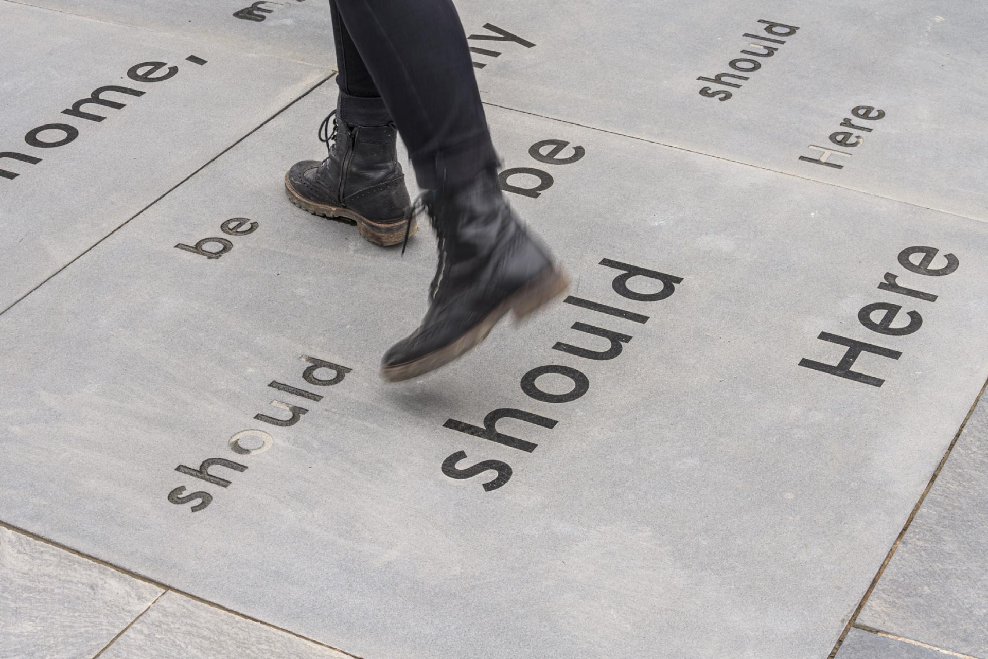 Footsteps on a stone path featuring text, highlighting artistic engagement at The Museum at Wordsworth Grasmere.