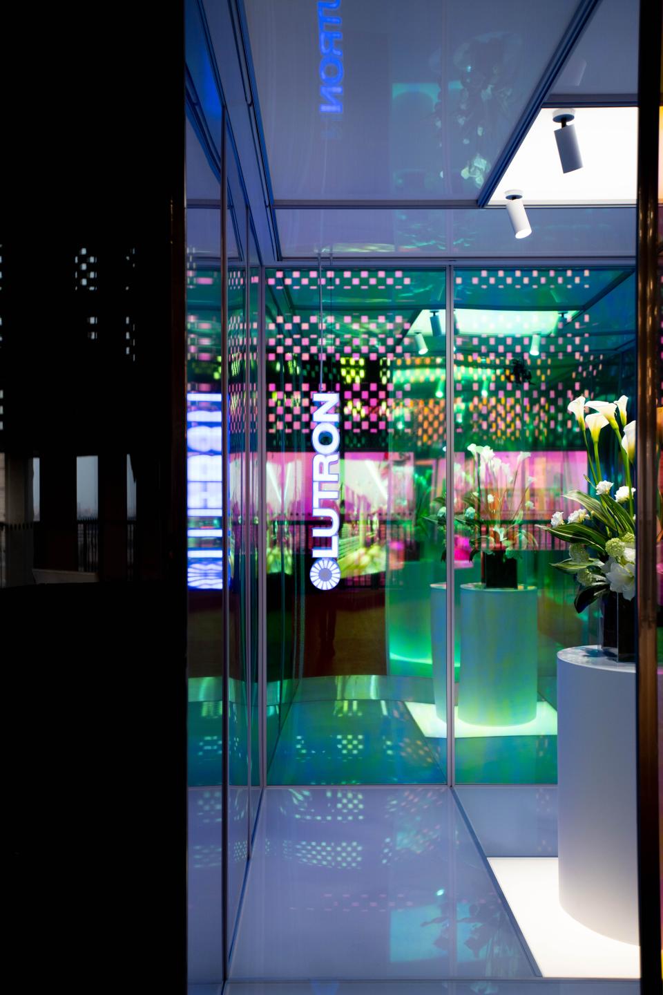 Lutron's interactive experience showcase, featuring vibrant lights and floral arrangements, highlighting innovative design concepts.