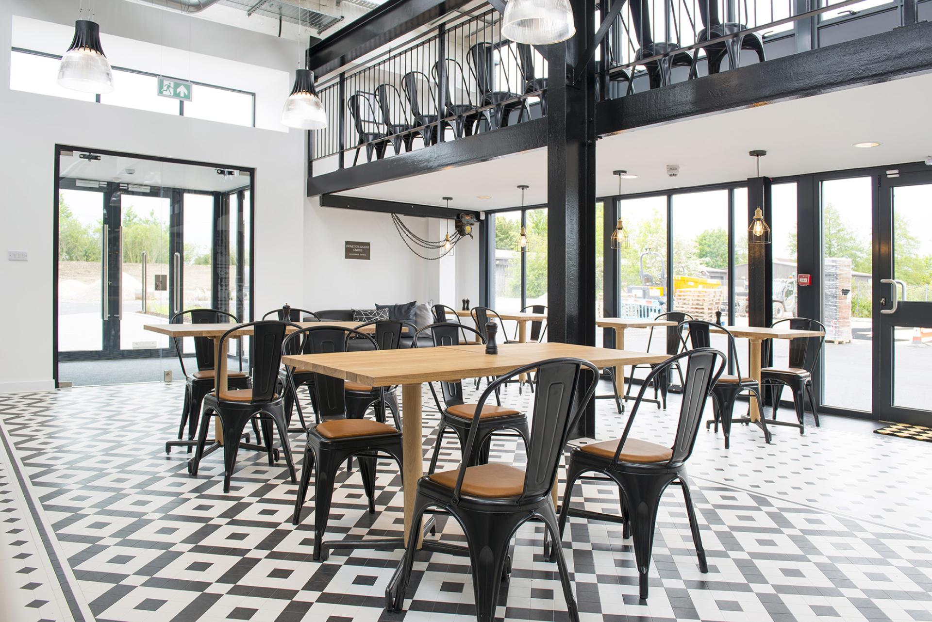 Industrial-style interior featuring Karndean Heritage Collection flooring, with wooden tables and black metal chairs in a spacious setting.
