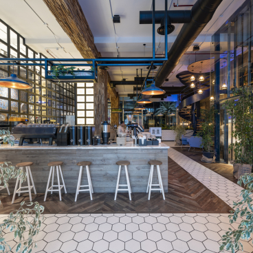 Stylish interior of Brew92 cafe featuring wooden elements, modern seating, and decorative plants, designed by Liqui Design.
