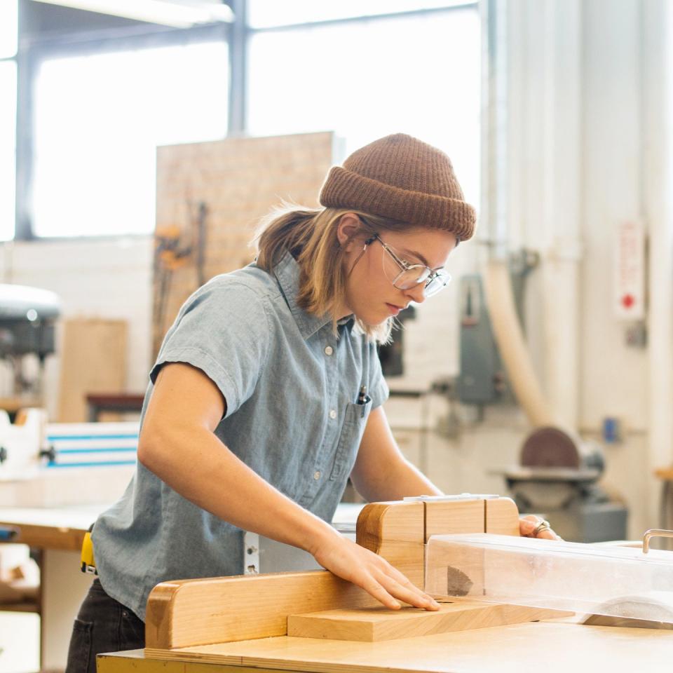 Midwest furniture designer Maggie Jo Sanderson working intently in her studio, showcasing her craftsmanship and design skills.