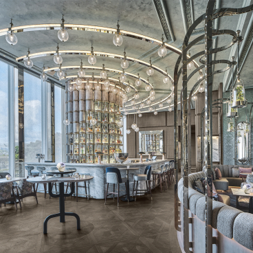 Stylish interior of Argo cocktail bar at Four Seasons Hong Kong, featuring elegant furnishings and a distinctive mirrored bar.