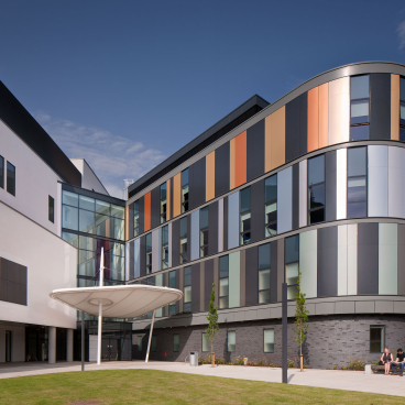 Modern healthcare facility designed by HLM, featuring colorful facades and welcoming outdoor space at NHS Lothian.