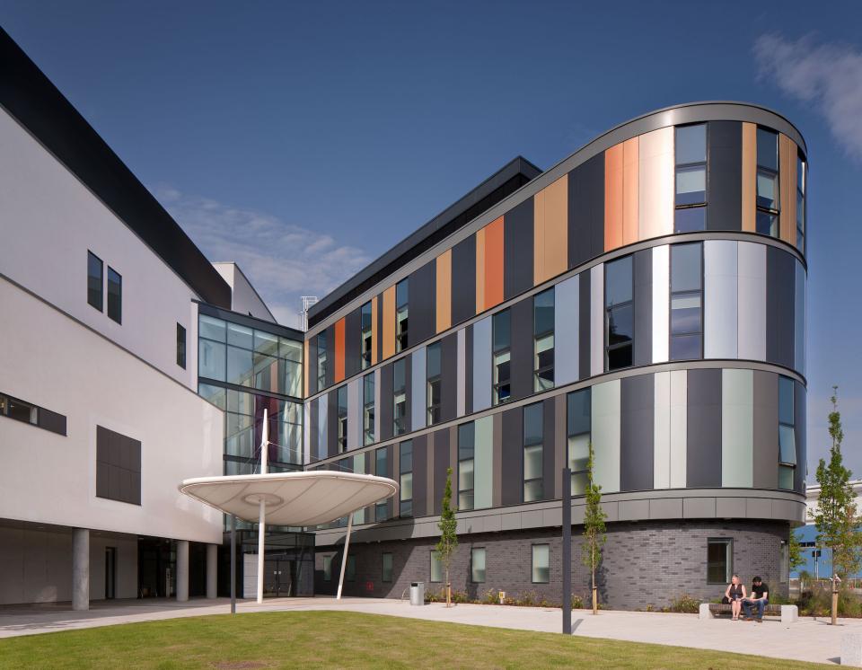 Modern healthcare facility designed by HLM, featuring colorful facades and welcoming outdoor space at NHS Lothian.