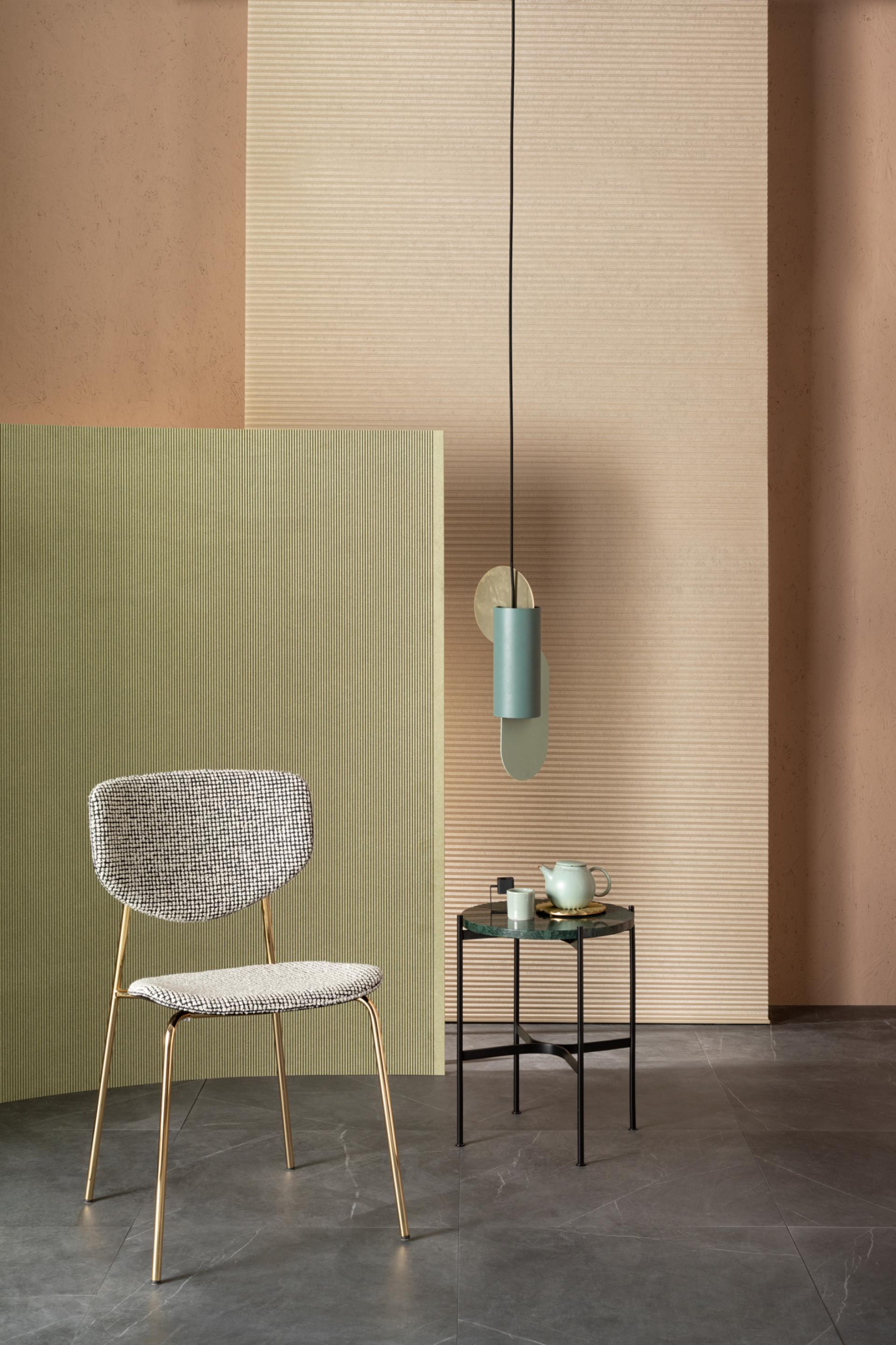 Contemporary furniture design featuring a stylish chair and a minimalist side table against textured wall panels.