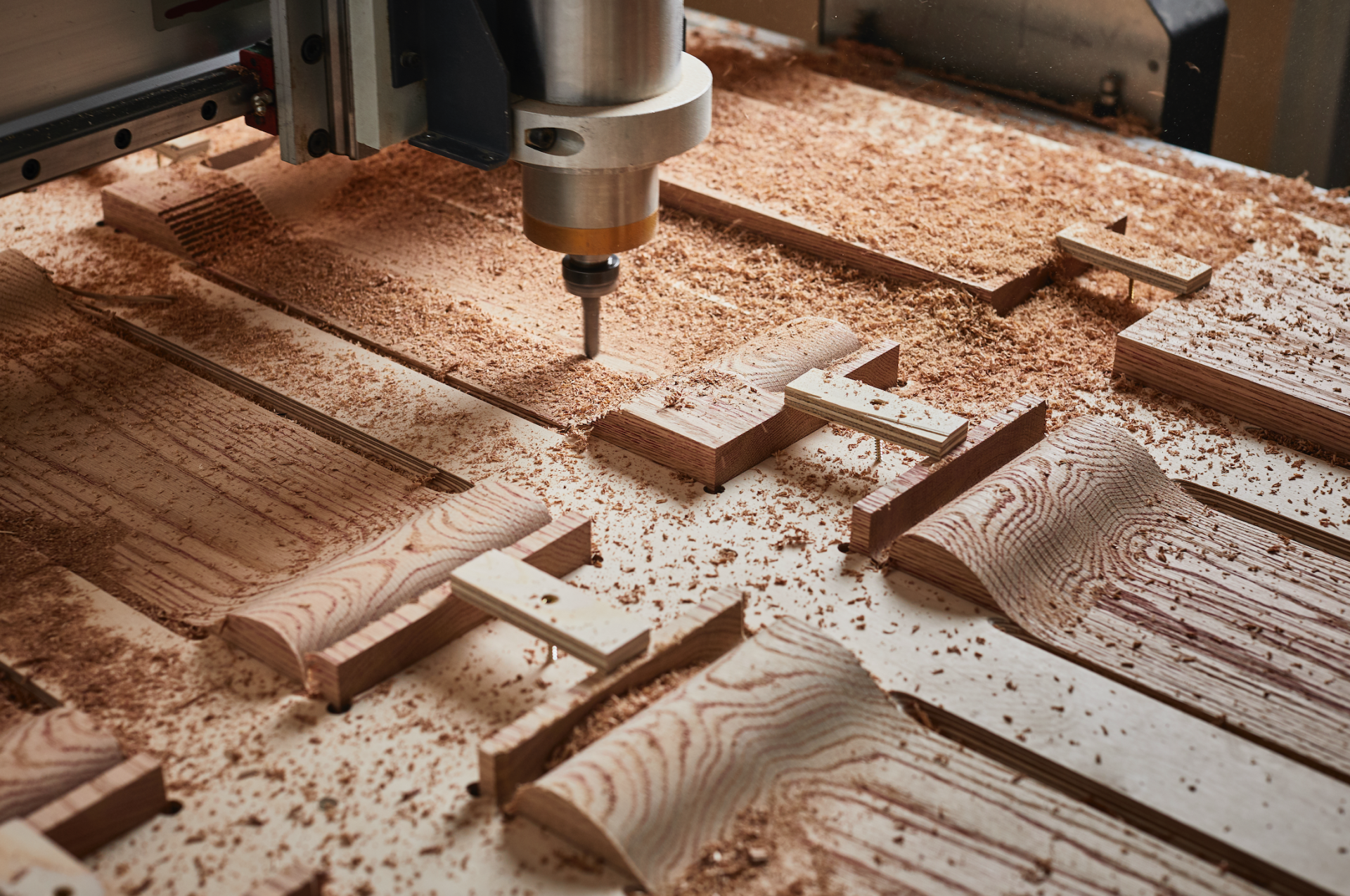 CNC machine carving red oak wood pieces for the Blushing Bar project by Chan + Eayrs and Sebastian Cox in Milan.