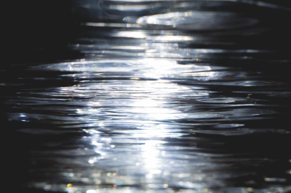 Reflections of light dancing on a water surface, showcasing the artistic potential of light in design.