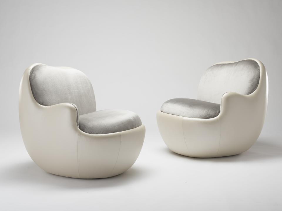 Stylish contemporary armchairs in cream and gray upholstery, showcasing modern design aesthetics from the Salon Art + Design exhibition.