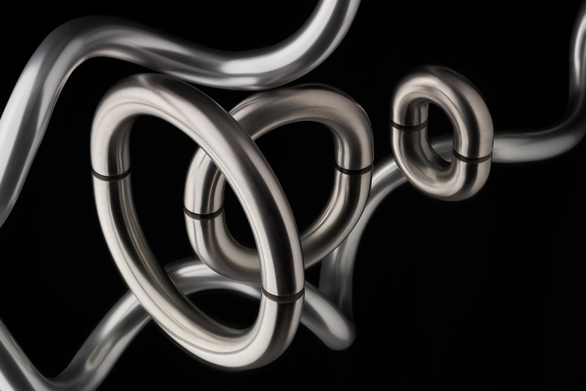 Sleek architectural ironmongery pieces in silver and metallic tones, showcasing Tom Dixon's modern design aesthetic.