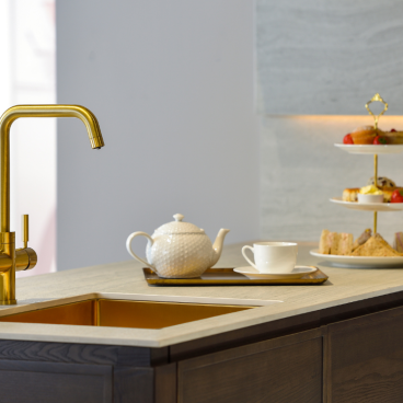 Luxury kitchen featuring a gold Pronteau Propure 4 IN 1 steaming hot tap alongside a tea set and elegant afternoon tea display.