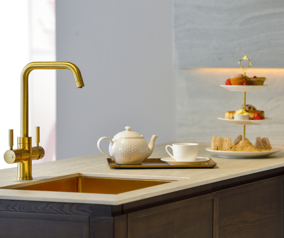 Luxury kitchen featuring a gold Pronteau Propure 4 IN 1 steaming hot tap alongside a tea set and elegant afternoon tea display.