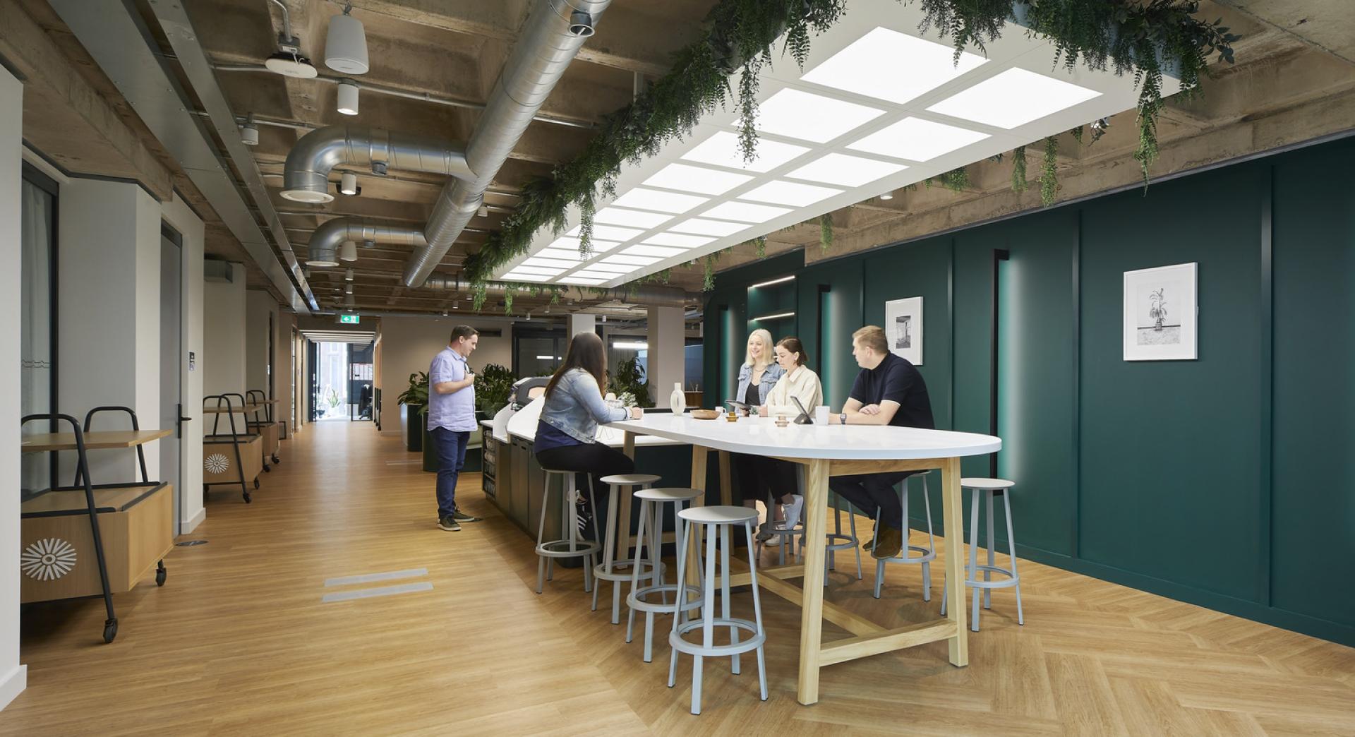 Collaborative workspace featuring diverse individuals discussing sustainability in a modern North West creative environment.