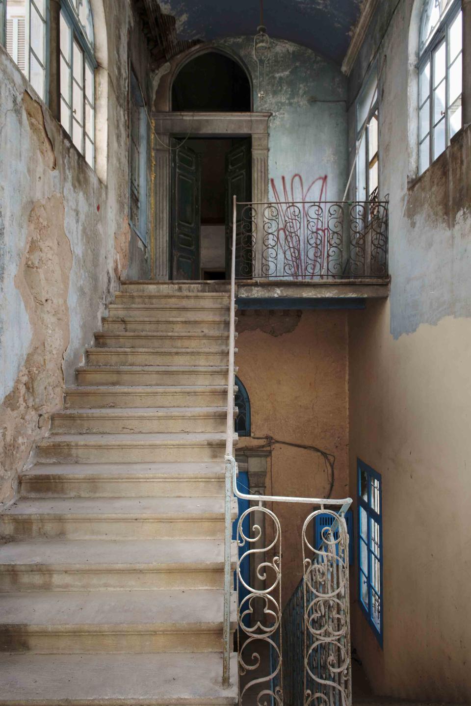 Interior view of BAYT K, showcasing 19th-century architecture, a staircase, and intricate ironwork in a historic Lebanese house.