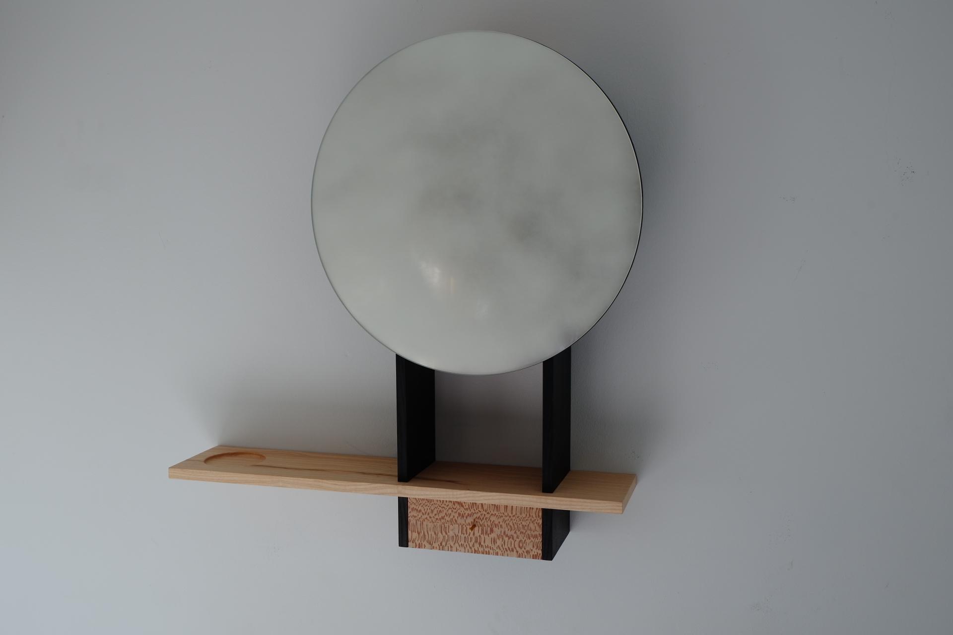 Modern wall-mounted mirror designed by Robert Bain, featuring a unique blend of wood and metal elements.