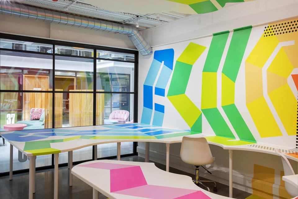 Vibrant workspace featuring colorful geometric designs on walls and furniture, showcasing HARU Stuck-on Design's innovative interior solutions.