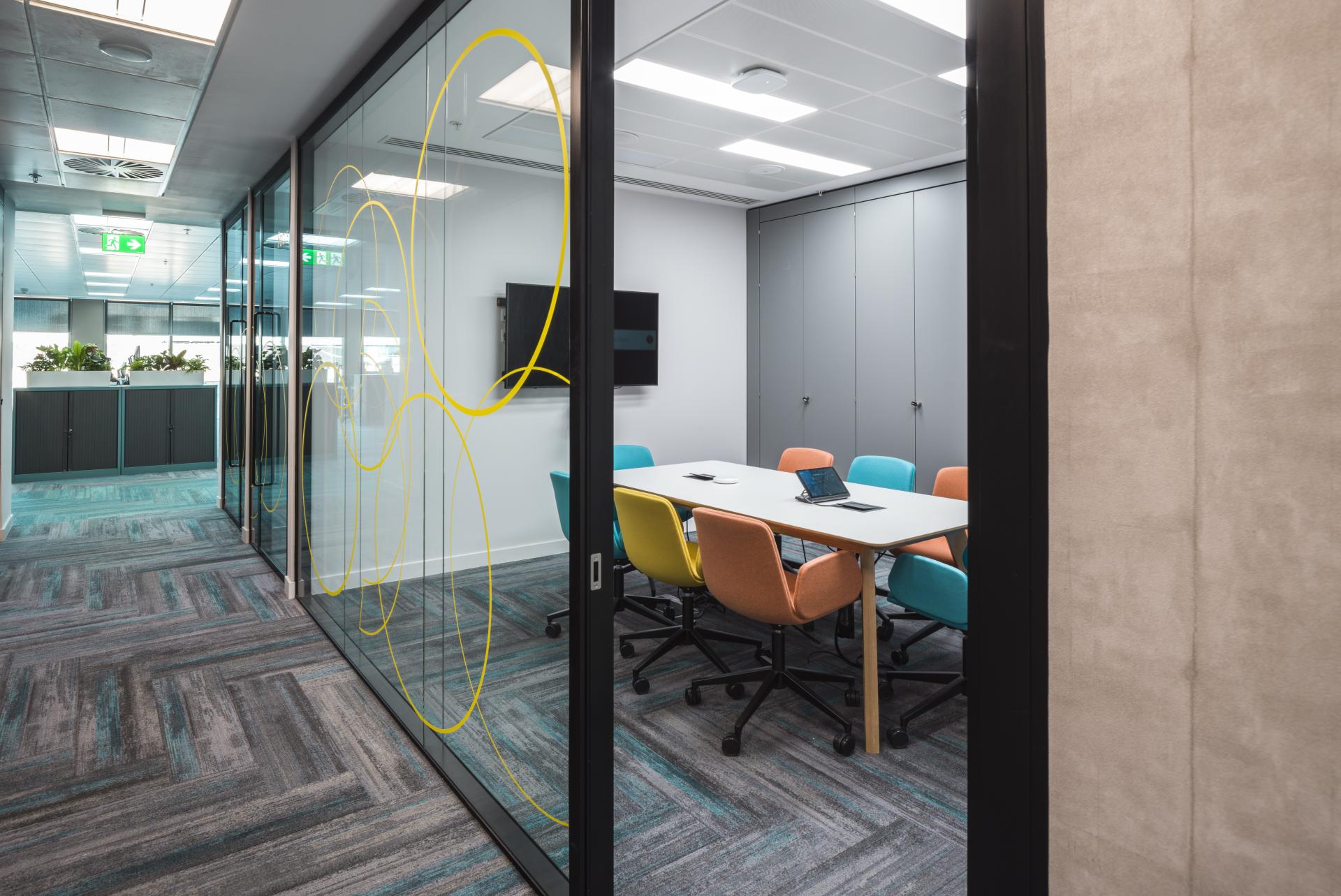 Modern office meeting room featuring colorful seating, sleek design elements, and WELL certification features in Edinburgh.