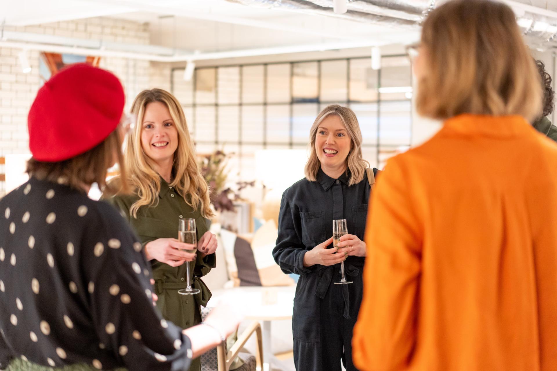 Women engaging in conversation during a sustainability seminar, promoting collaboration and discussions on value engineering solutions.