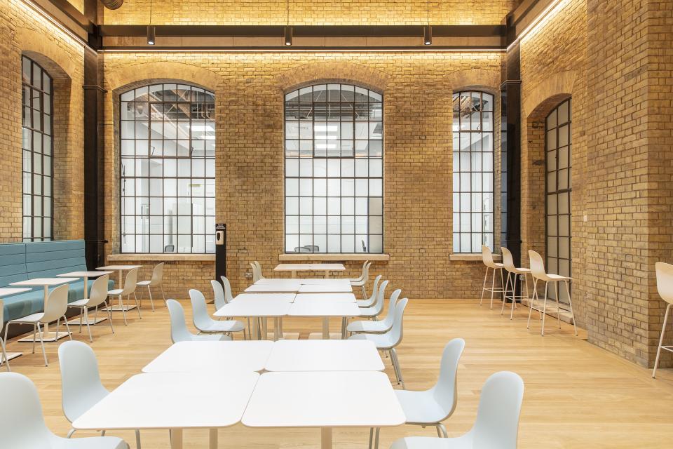 Modern office space in The National Gallery's One Accommodation Hub featuring wooden floors, large windows, and collaborative seating.
