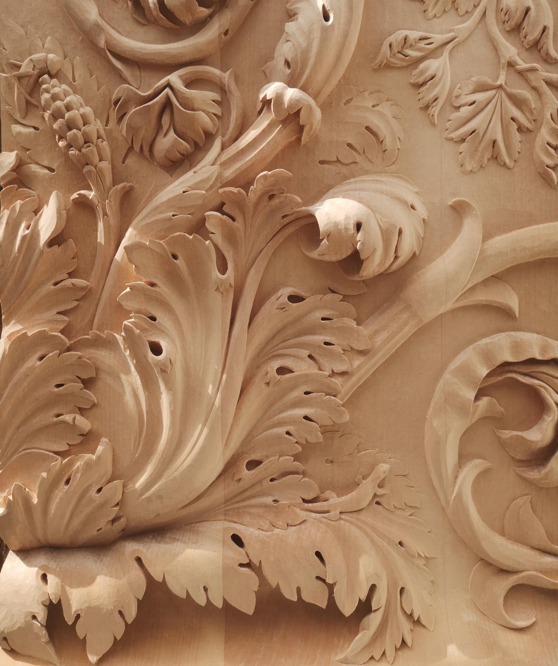 Intricate woodcarving featuring detailed floral designs, showcasing craftsmanship and artistry emphasized in Louisa Pacifico's work.