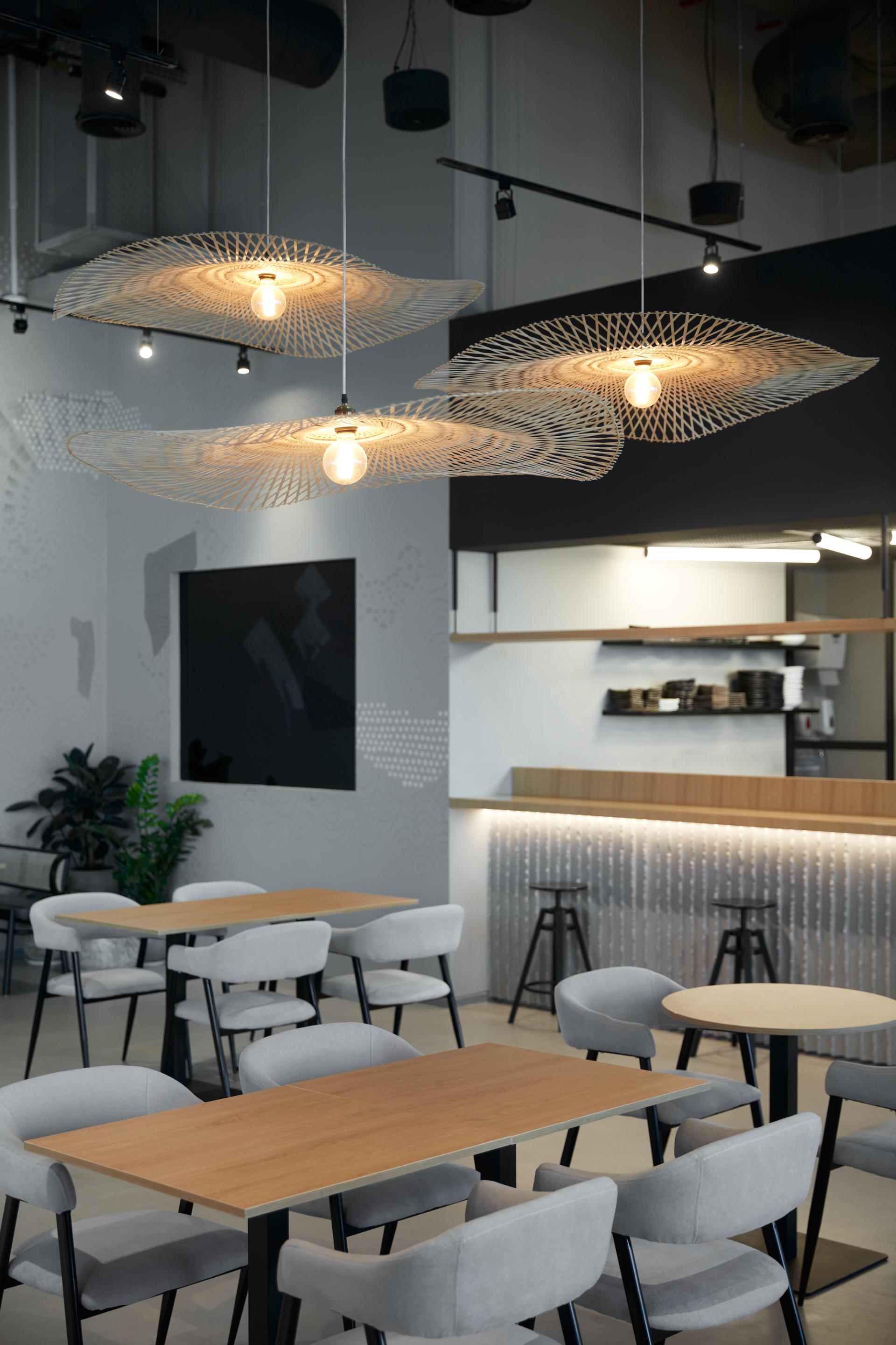 Elegant dining area of Origami restaurant in Dubai featuring stylish gray chairs, wooden tables, and modern pendant lights.