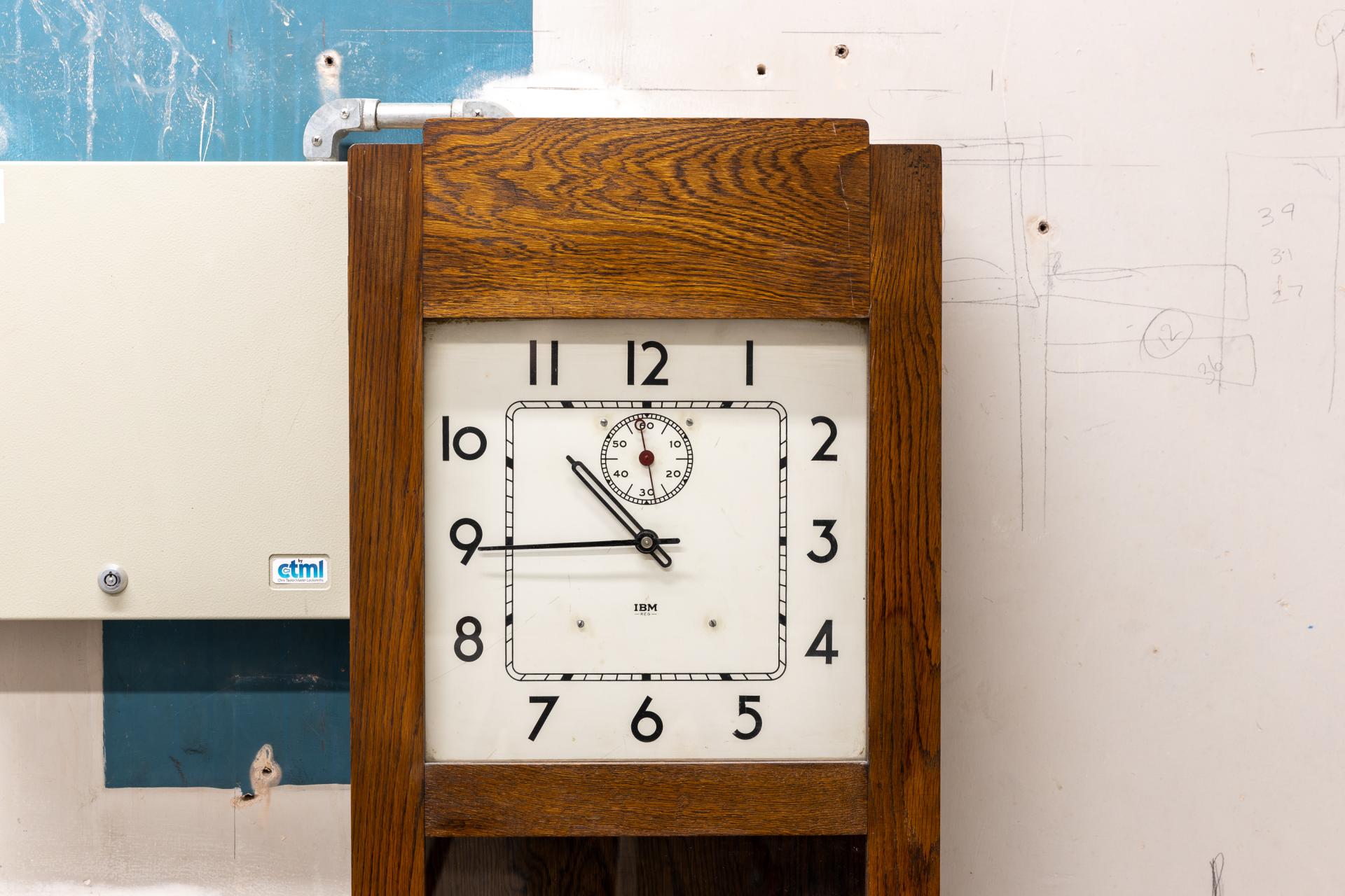Vintage clock with wooden frame, showcasing timekeeping in historic venue, symbolizing New Century's community transformation.