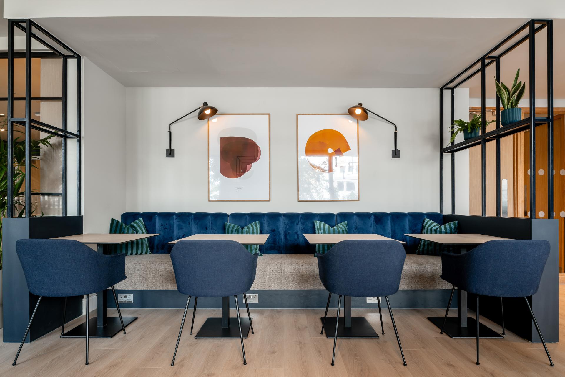 Modern co-living space at The Apiary featuring stylish seating, artwork, and lush greenery, showcasing Ekho Studio's interior design.