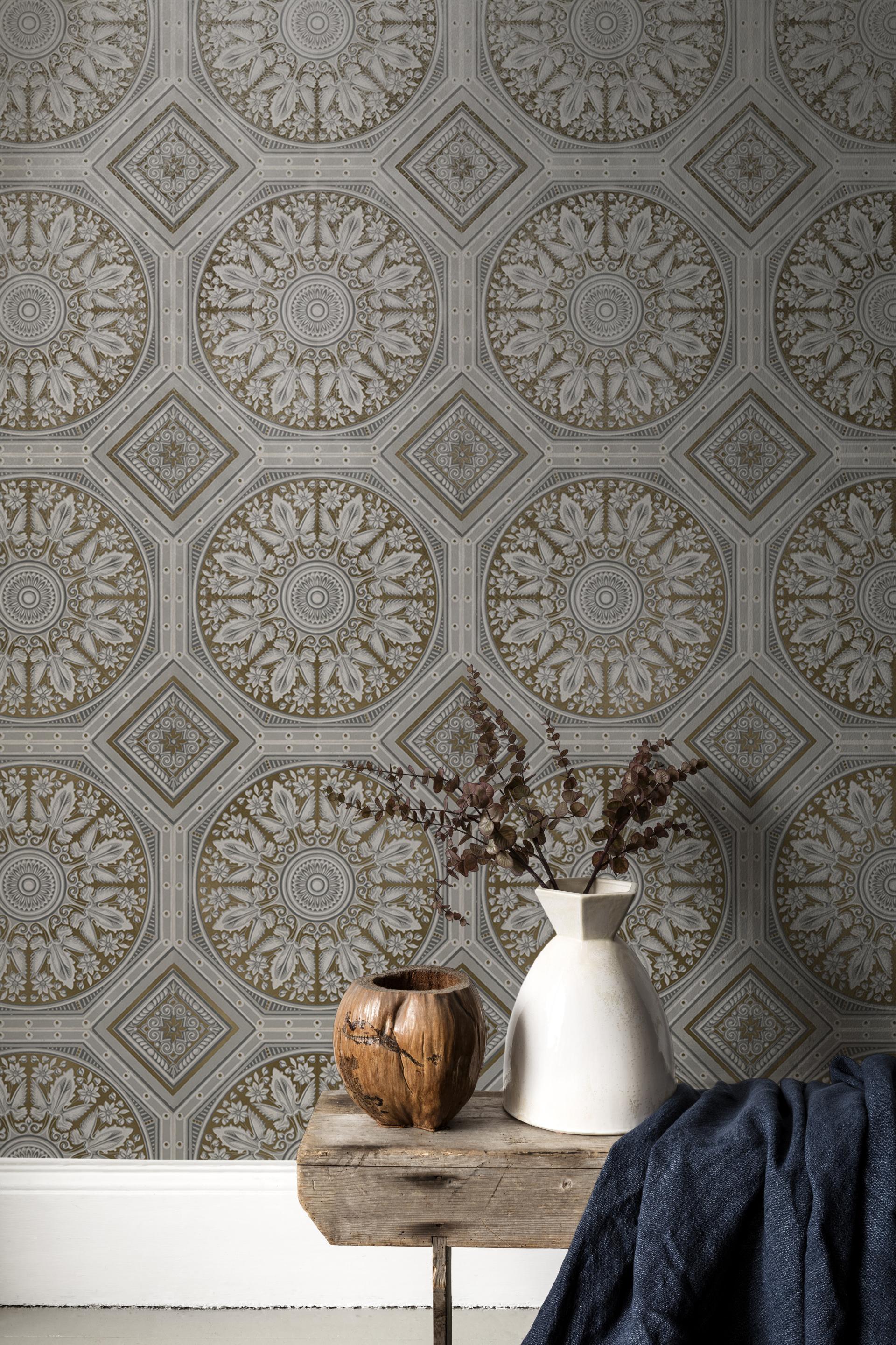 Elegant traditional V&A wallpaper design featuring intricate floral patterns, complemented by a wooden vase and decorative elements on a rustic table.