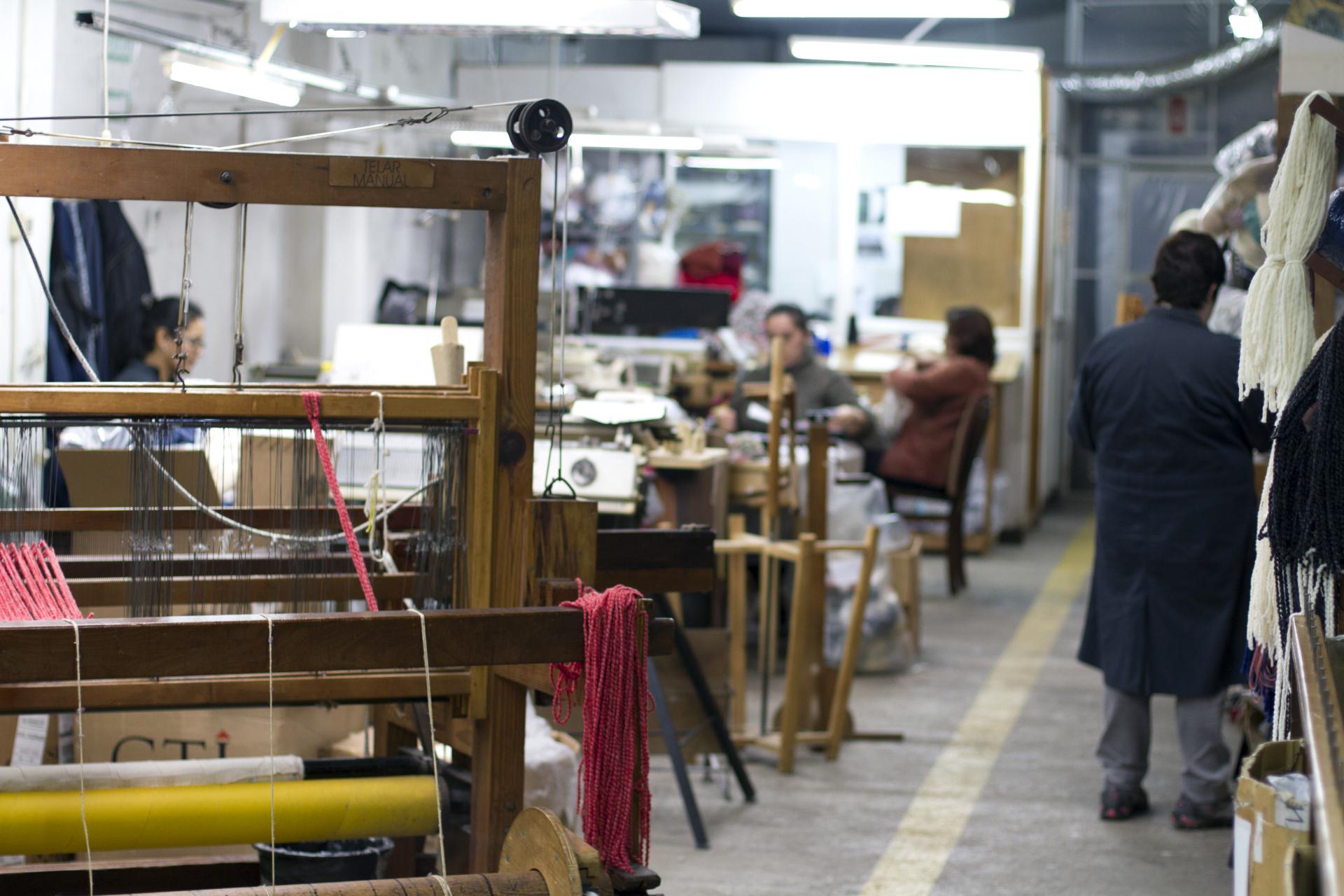 Craftspeople work on textile weaving and chair production in a vibrant workshop, showcasing Carolina Palombo's Tutura chair materials and processes.
