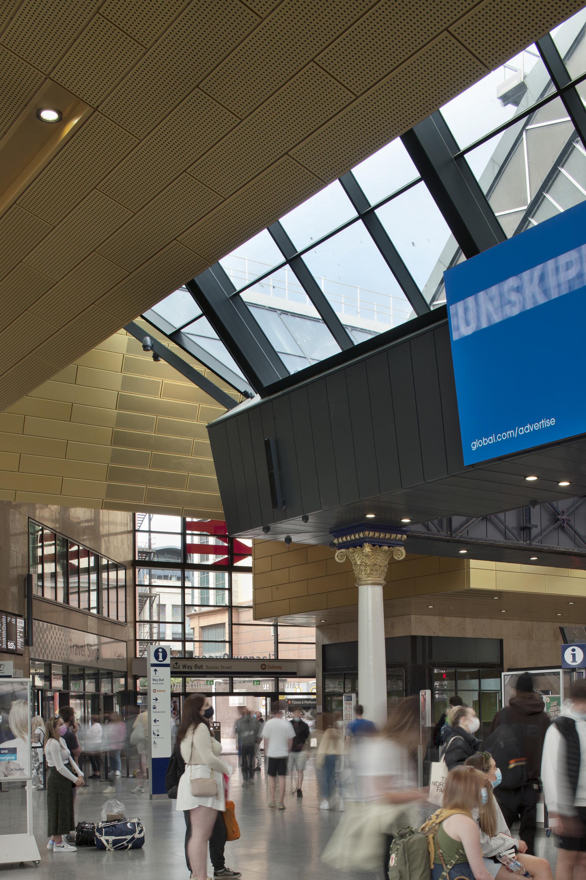 Modern Glasgow transportation hub interior featuring a blend of architecture and busy commuters.