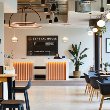 Modern reception area of Central House, featuring stylish decor, seating, plants, and a welcoming desk designed by SpaceInvader.