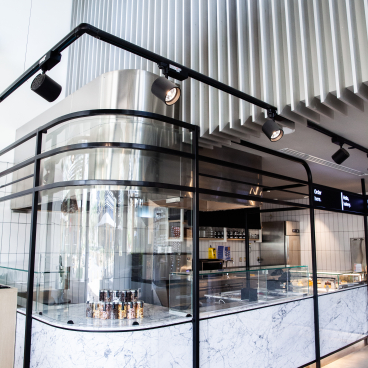 Modern pastry shop interior featuring a sleek marble counter and glass display, designed for Chunk in Riyadh.