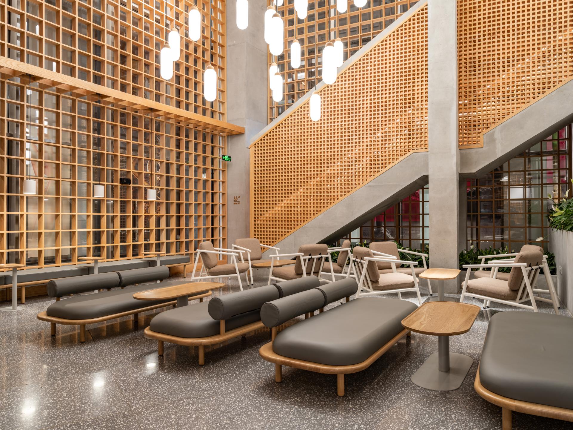 Sophisticated interior of Brew92 coffee shop featuring Japandi design with sleek furniture, wooden lattice wall, and modern lighting.