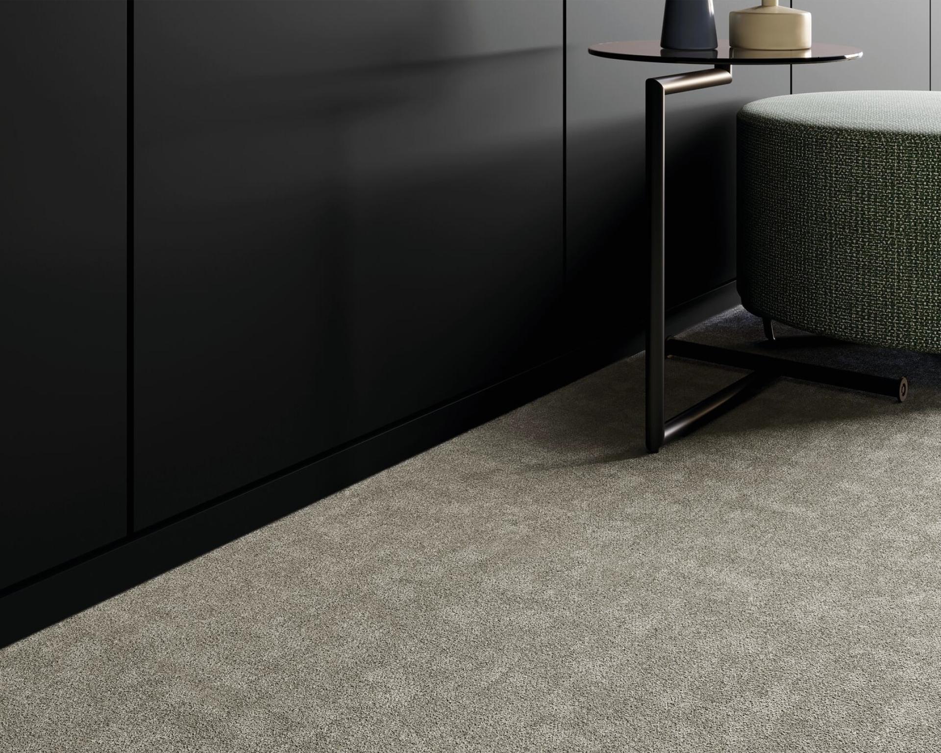Tessera Union collection carpet in a stylish interior featuring dark walls, a green ottoman, and a modern side table.