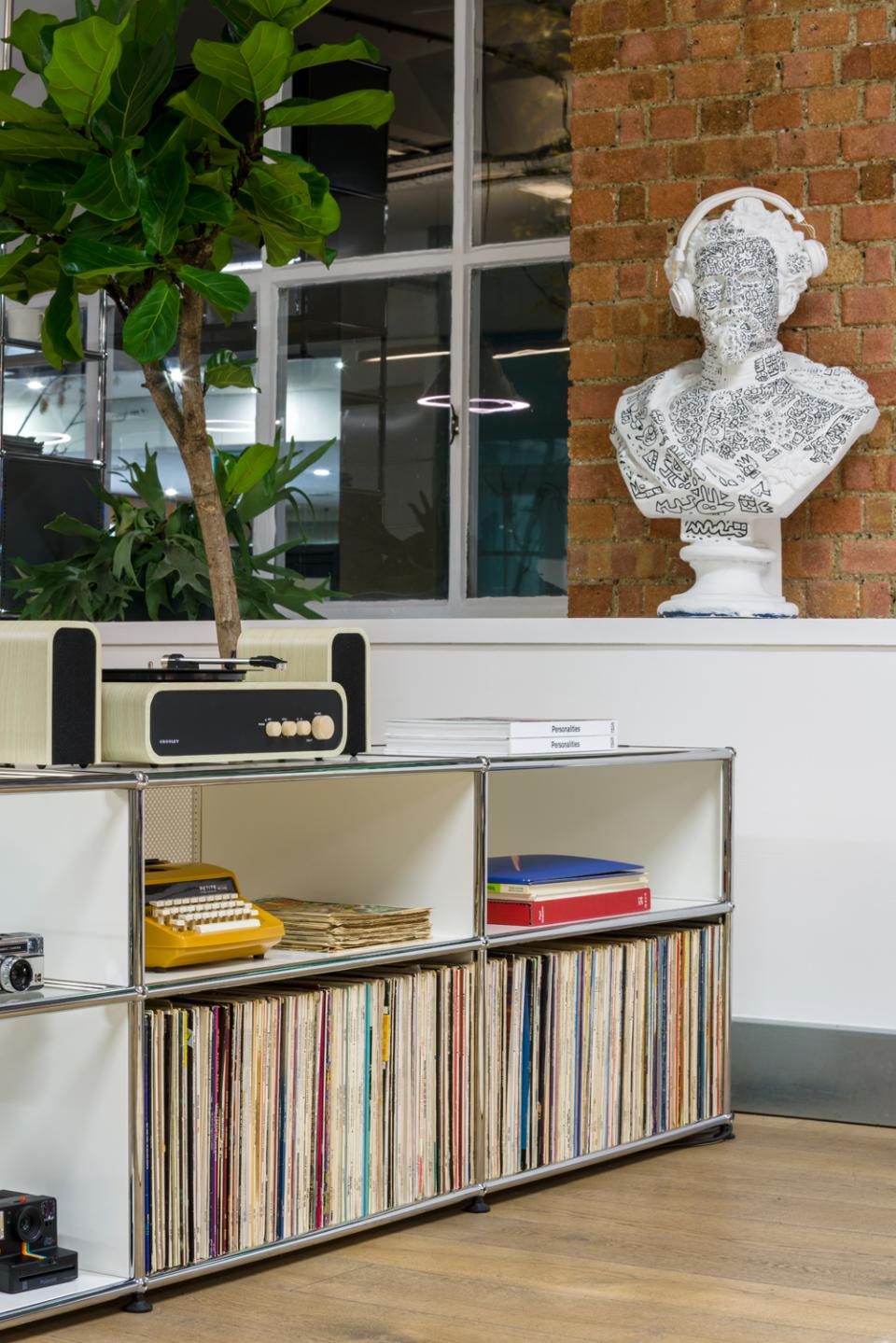 Modern interior showcasing USM modular furniture, vintage record player, books, and a unique bust sculpture in Clerkenwell showroom.