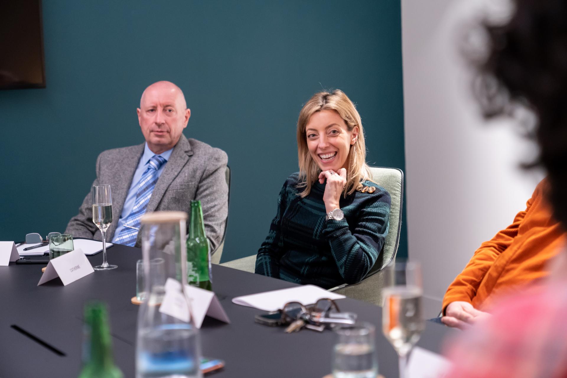 Colleagues engaged in a discussion about the future of education at a conference table, highlighting active collaboration.