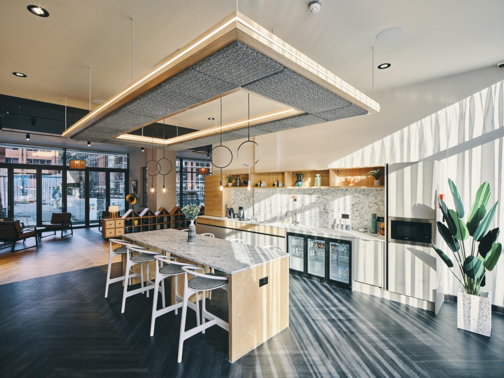 Modern kitchen design featuring marble countertops, elegant lighting, and stylish cabinetry in a Manchester interior.