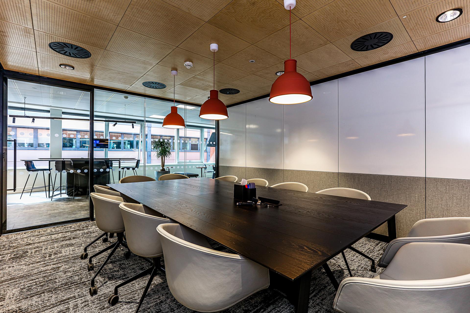 Modern meeting room at Domestic & General's Wimbledon HQ featuring a large table, whiteboard, and ambient lighting.