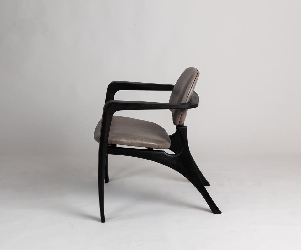 Modern designer chair with sleek black wooden frame and comfortable grey upholstery, highlighting Bristol's creative craftsmanship.