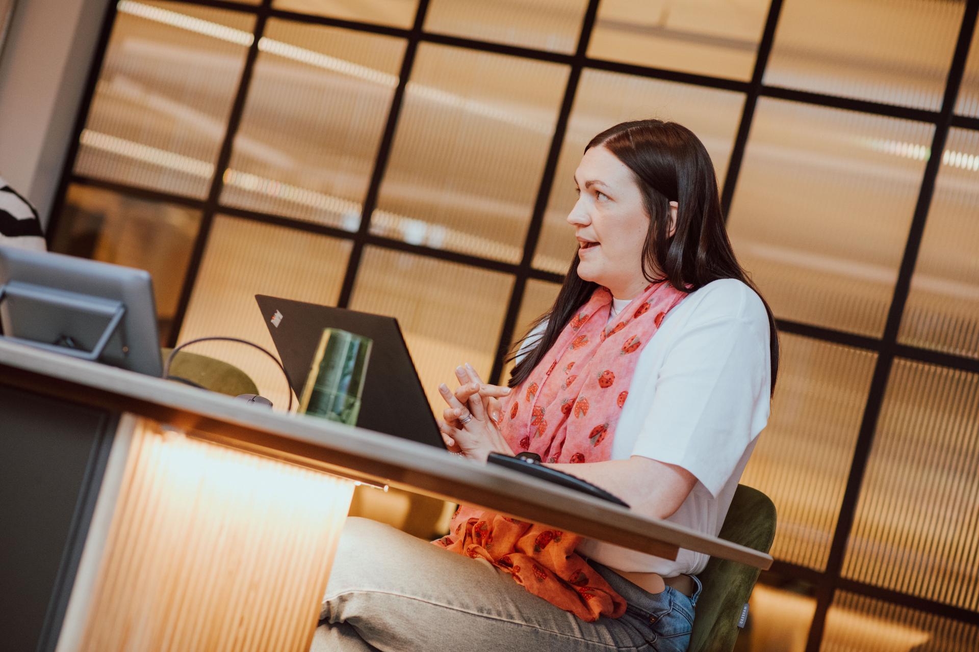 Creative collaboration session featuring a woman engaged in discussion about interior design at SCENE Interiors, Manchester Academy.