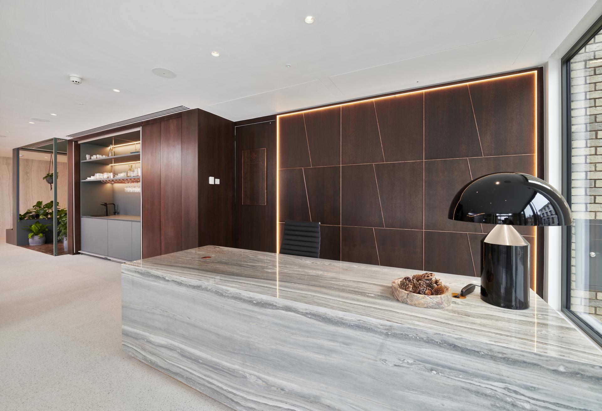 Elegant reception area featuring nature-inspired design elements, modern lighting, and polished stone countertops by SpaceInvader.