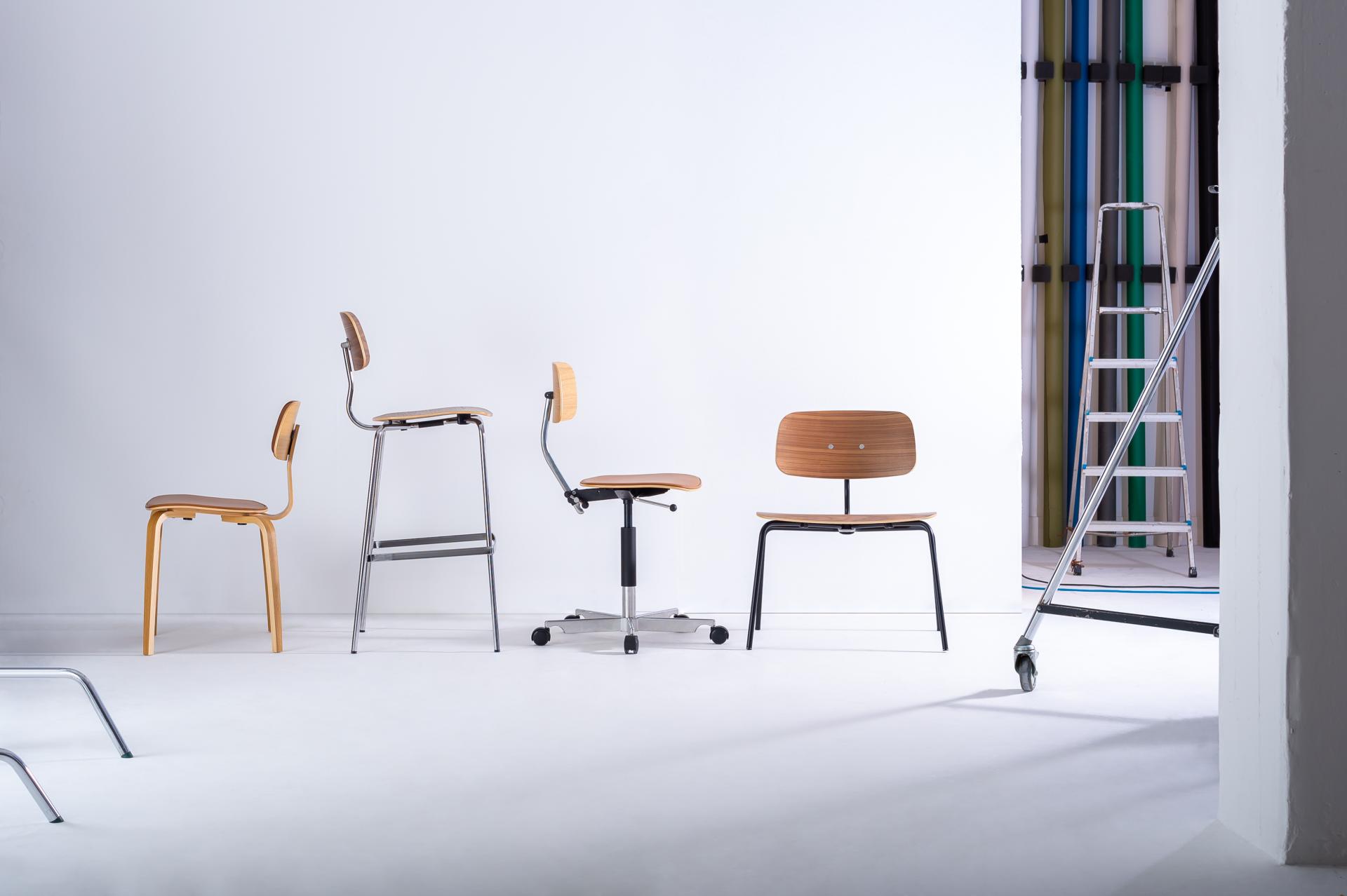 A display of various contemporary chairs in a minimalist studio setting, showcasing innovative design for the (Re)act event.