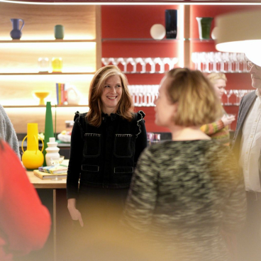 Group of professionals engaging in conversation in a modern workplace, highlighting flexibility and collaboration themes.
