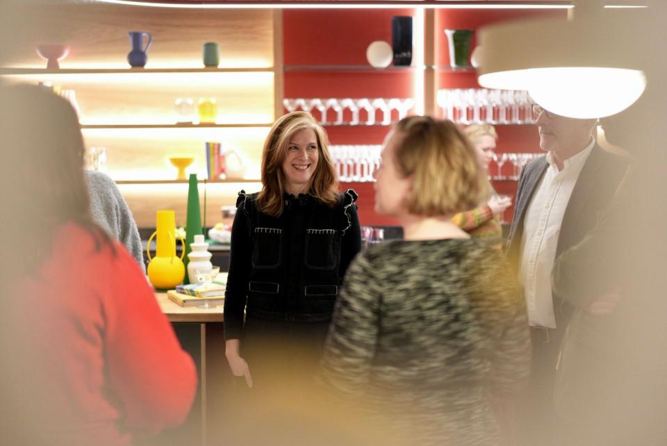 Group of professionals engaging in conversation in a modern workplace, highlighting flexibility and collaboration themes.