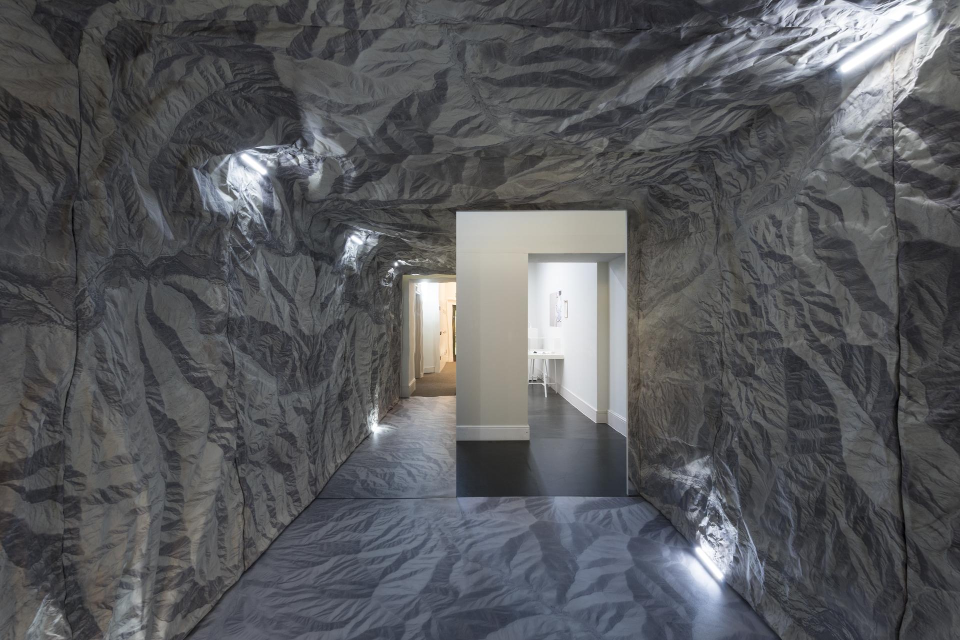 Interior view of a textured corridor with artistic lighting, showcasing innovative architectural design by Nissen Richards Studio.