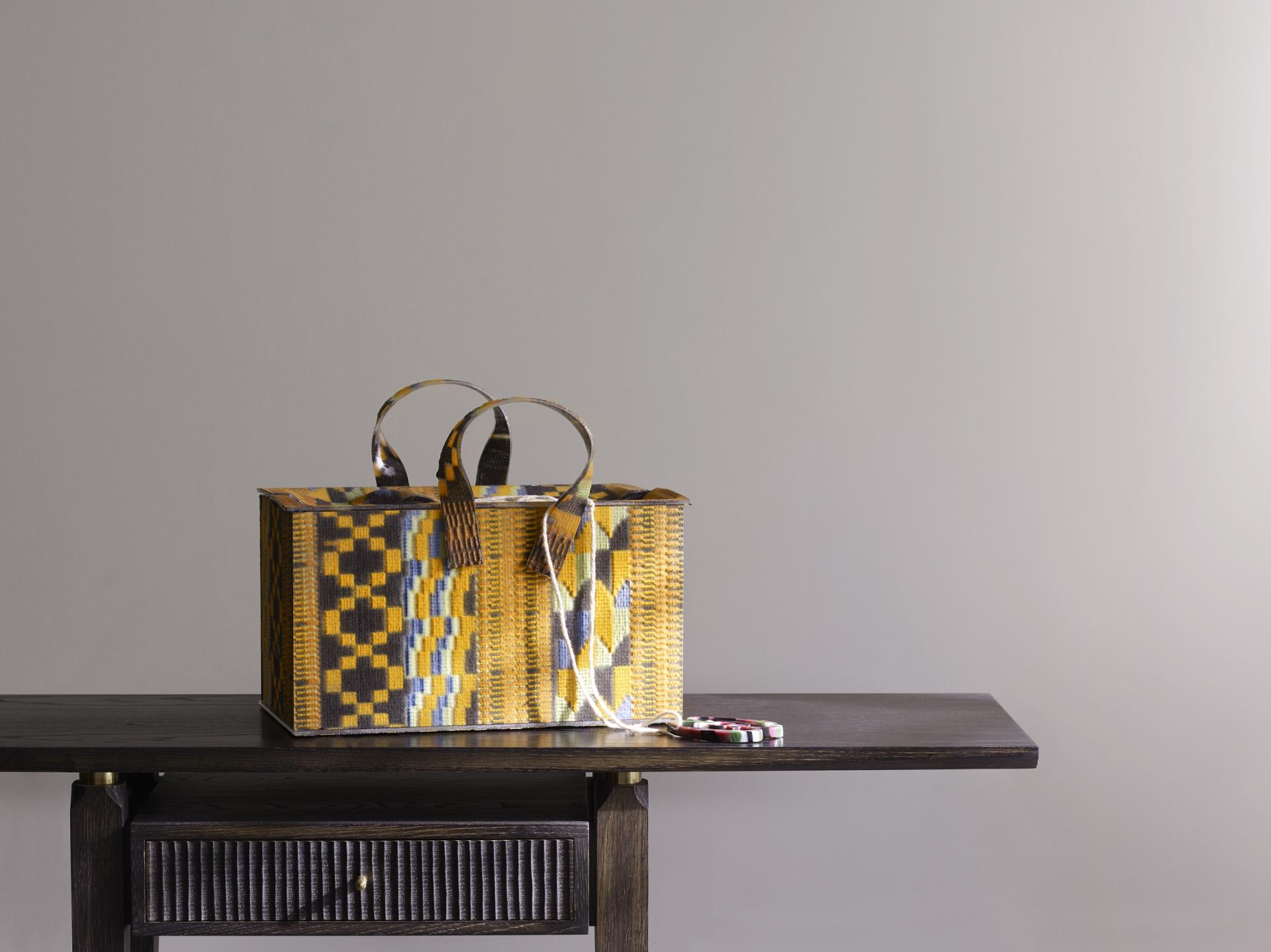 Colorful woven bag displayed on a wooden table, showcasing contemporary craft at Collect's 19th edition in Somerset House.