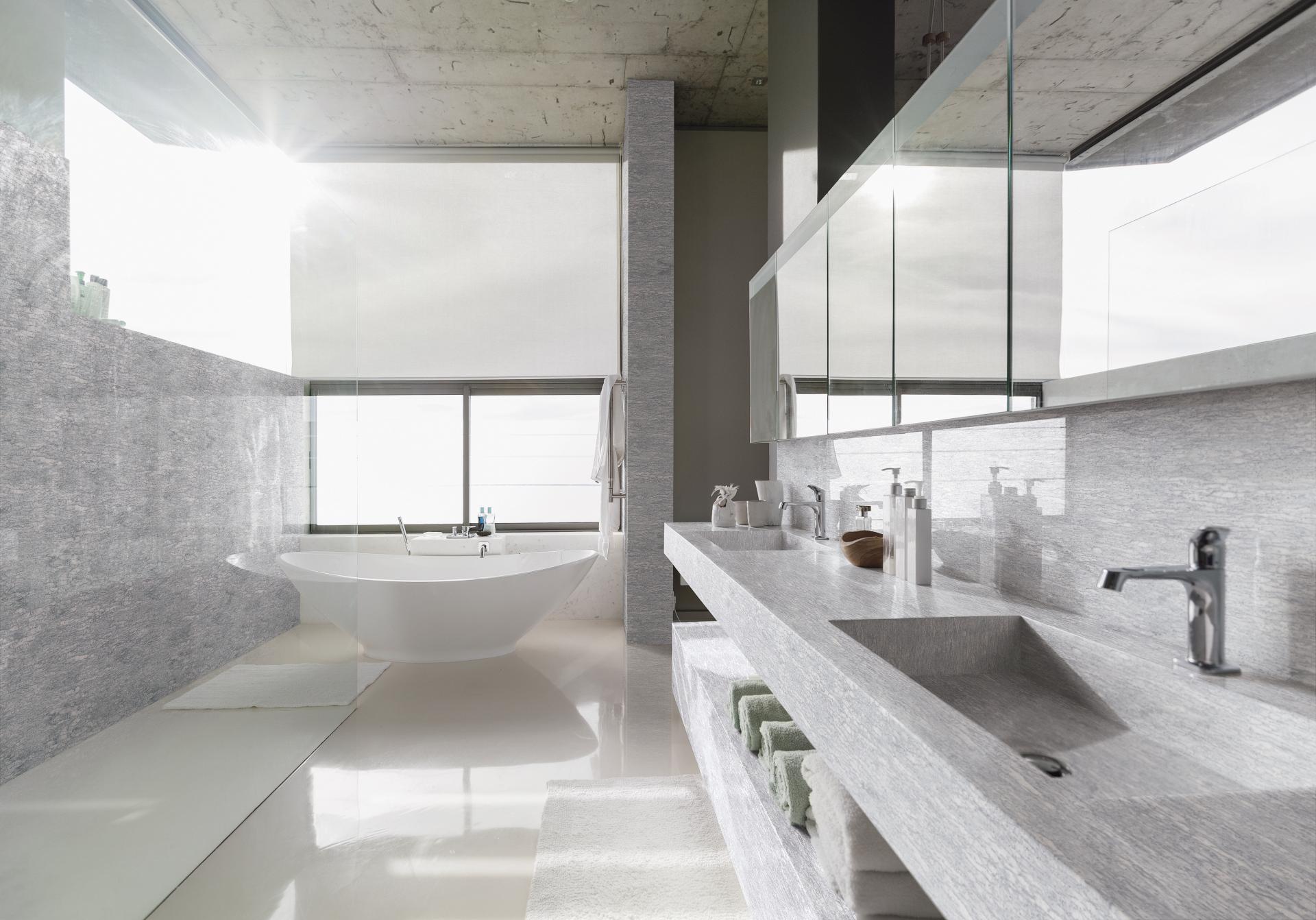 Modern bathroom featuring Hanex® solid surface vanities, a freestanding tub, and sleek design elements, showcasing elegance and functionality.